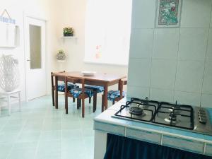 a kitchen with a stove and a dining table at Casa Tatillo - Immobilevante in Ponza