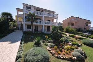 a large house with a garden in front of it at Apartments Marinela in Njivice