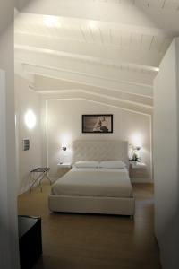 a white bedroom with a large bed and white ceilings at B&B La Dolce Vita in Fondi