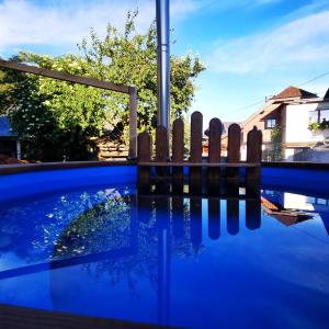 a blue swimming pool with a wooden fence at ALPINpelso in Sankt Michael im Lungau