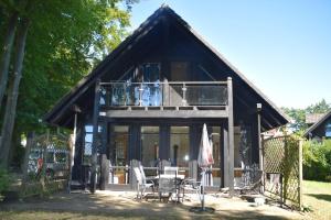 a house with a balcony and a table and chairs at Ferienhaus Plau am See direkt am Strand in Plau am See