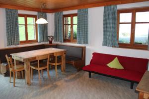 een eetkamer met een houten tafel en een rode bank bij Ferienwohnung in der Schoß in Schruns