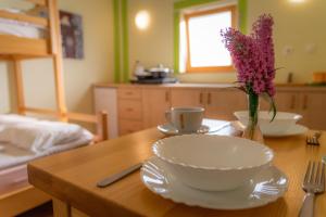 una mesa con dos tazones y un jarrón con flores. en Počitniška hiška Pod Skalco en Kamnik