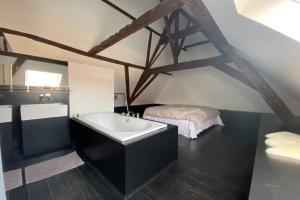een badkamer met een bad en een bed bij GLORIA LOFT GENT in Gent