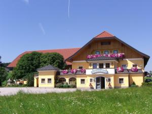 ein großes gelbes Gebäude mit Blumen darauf in der Unterkunft Landhotel Gersbach-Gut in Henndorf am Wallersee