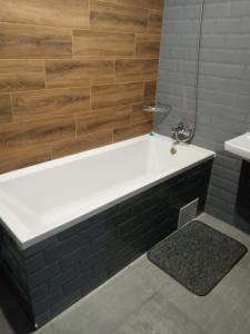 een badkamer met een bad en een wastafel bij Посуточно отличная квартира в центре in Oezjhorod