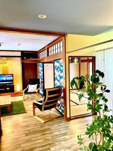 uma sala de estar com um sofá e uma cadeira em Ishimaru House em Seki
