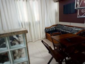 uma sala de estar com uma mesa e um sofá em Cond. Hotel Âncora em frente Praia do Peró em Cabo Frio