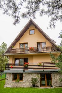 a house with a balcony and flowers on it at POKOJE GOŚCINNE WILCZNIK 12 in Zakopane