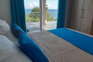una camera da letto con un letto con vista sull'oceano di Appartement Perle Bleue a Le Diamant