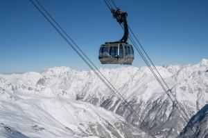 ein Skilift, der über einen schneebedeckten Berg fliegt in der Unterkunft Hotel Valentin in Sölden