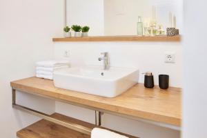 a bathroom with a white sink on a wooden counter at Glücksferien- Sonnenhut in Glücksburg