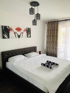 a bedroom with a bed with two remote controls on it at Marius Apartment in Braşov