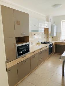 a kitchen with white cabinets and a stove top oven at Marius Apartment in Braşov