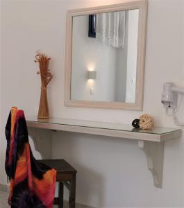 einen Spiegel auf einer Theke in einem Zimmer in der Unterkunft Aretousa Villas in Perissa