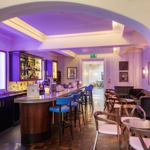 a bar in a restaurant with purple lighting at Southernhay House Hotel in Exeter