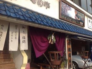una tienda frente a un edificio con una cortina púrpura en Fukumakan, en Matsue