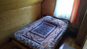 Cama pequeña en habitación de madera en Хатина на Порташі, en Tatariv