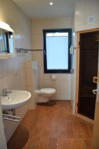 bagno con servizi igienici, lavandino e finestra di Ferienhaus Plau am See in Wassernähe a Plau am See