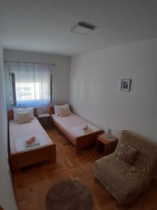 un salon avec deux lits et un canapé dans l'établissement Apartman DORA, à Trebinje