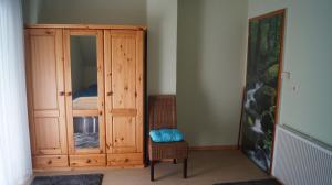 1 dormitorio con armario de madera y silla en Helmine, en Mettlach