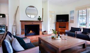 a living room with a table and a fireplace at Cherubino Wines Guest Houses in Wilyabrup