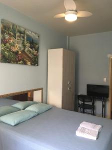 a bedroom with a bed and a cabinet and a television at Hostel Vergueiro in São Paulo