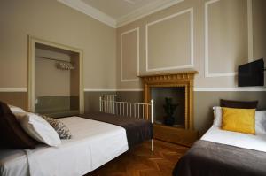a bedroom with two beds and a fireplace at La Maison B in Bergamo
