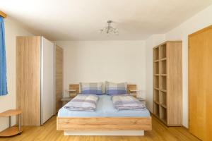 1 dormitorio con 1 cama con sábanas y almohadas azules en Haus Schimpfössel, en Flirsch