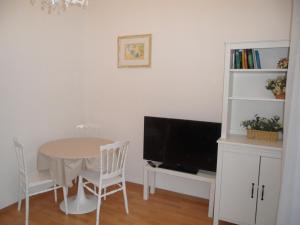 een eetkamer met een tafel en een televisie bij La Vie En Rose in Rapallo