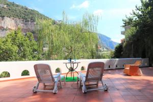 um pátio com 2 cadeiras e uma mesa no telhado em Villacarrino em Positano