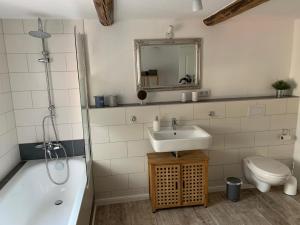 ein Badezimmer mit einem Waschbecken, einer Badewanne und einem WC in der Unterkunft Ferienwohnung im Hooptal in Negenborn