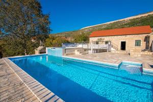 a large blue swimming pool next to a building at Villa Stipanovi Dvori in Vodenjak