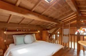 a bedroom with a bed in a room with wooden ceilings at L'Esprit Montpel "La Cabane-Chalet de Montagne" in Vendargues