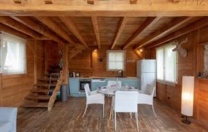 a kitchen with a dining table and white chairs at L'Esprit Montpel "La Cabane-Chalet de Montagne" in Vendargues