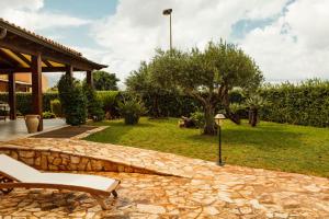 a patio with a bench and a stone wall at Cornino Bay in Custonaci