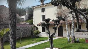 een wit huis met bomen in de tuin bij B&B Antico Borgo Marcemigo in Tregnago