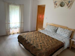 a bedroom with a bed and a window at La Măriuca in Bicaz