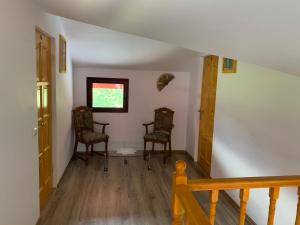 a hallway with two chairs and a window at La Măriuca in Bicaz +15 photos