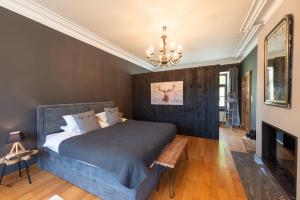 a bedroom with a bed and a chandelier at Le Marronnier in La-Roche-en-Ardenne