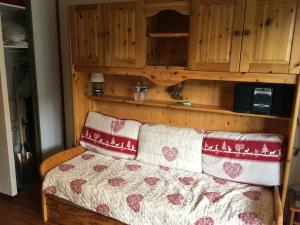 a couch in a living room with wooden cabinets at Appartement aux Menuires in Les Menuires