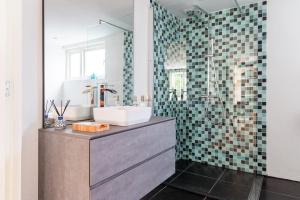 a bathroom with a sink and a shower at Gastenverblijf KortVertoef in Kortenhoef