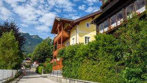 a yellow house with a balcony on a street at Villa Lilly - Luxus Appartements im Villenviertel in Bad Ischl