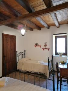 a bedroom with a bed and a table and a window at Borgo i Stritti in Petralia Soprana
