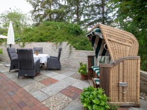 une terrasse avec une table, des chaises et un parasol dans l'établissement Haus Seeschwalbe, à Spiekeroog