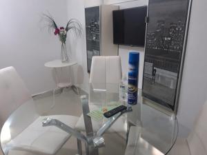 una mesa de cristal con mando a distancia sentada en una silla en Apartamentos Marques De La Merced, en Málaga