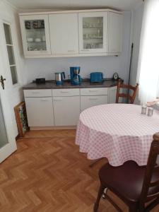 a kitchen with a table with a pink table cloth on it at Pension Becker Luckenwalde in Luckenwalde