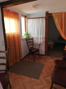 a living room with chairs and a table and windows at Pension Becker Luckenwalde in Luckenwalde