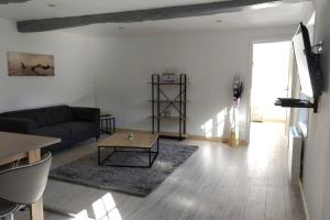 ein Wohnzimmer mit einem Sofa und einem Tisch in der Unterkunft charmante maison normande luneray in Luneray