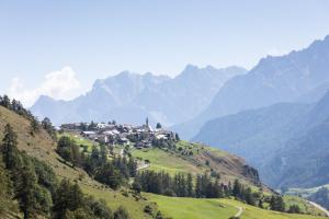 un pueblo en una colina con montañas en el fondo en Meisser Romantica "adults only" en Guarda
